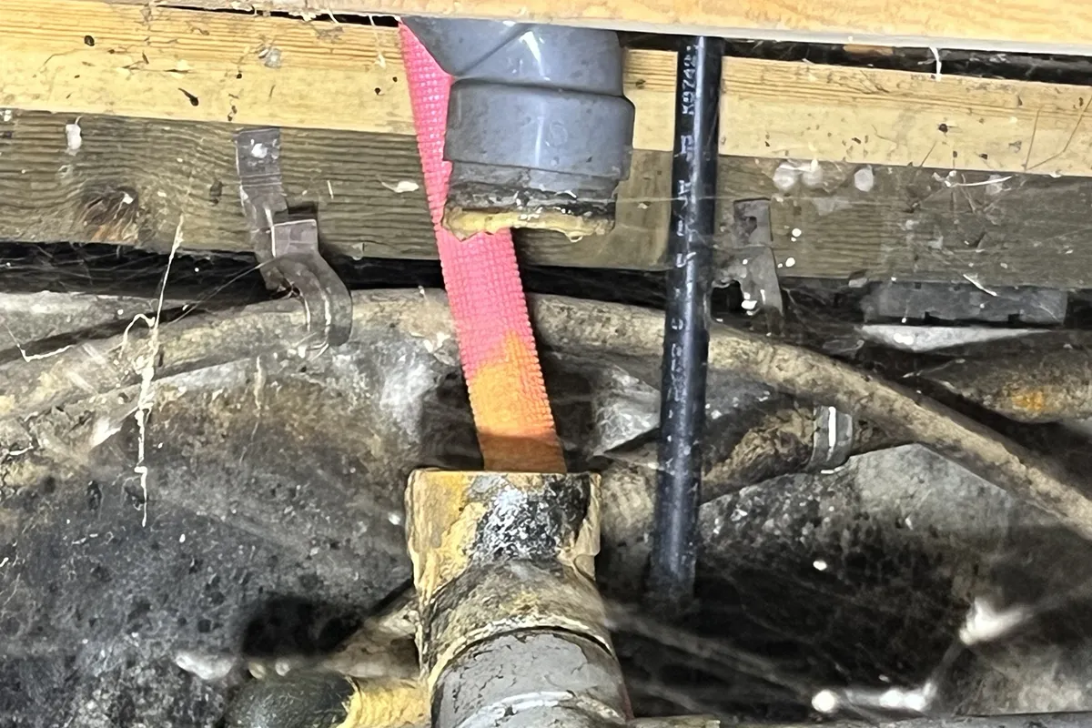 床下で外れた排水管の接続部のアップ写真。水濡れ補償の対象となる突発的な事故の実例