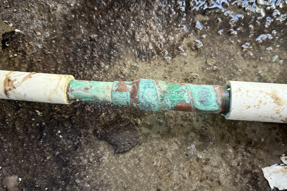 緑青や錆が全体に広がった銅管。経年劣化による床下漏水の典型例で火災保険の対象外