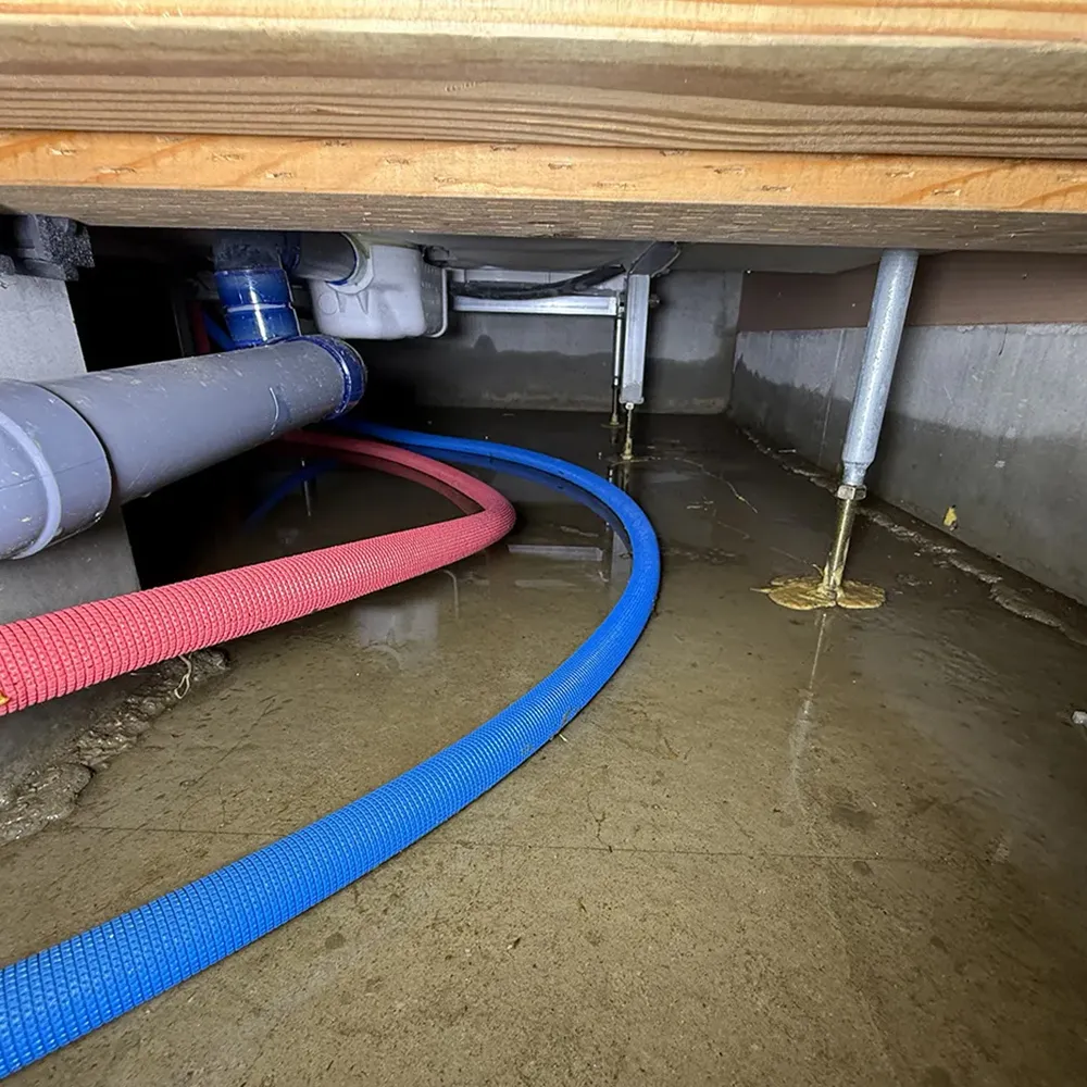 さいたま市の戸建て住宅で線状降水帯による豪雨後、床下点検口から床下に滞留した雨水の水位を確認している様子